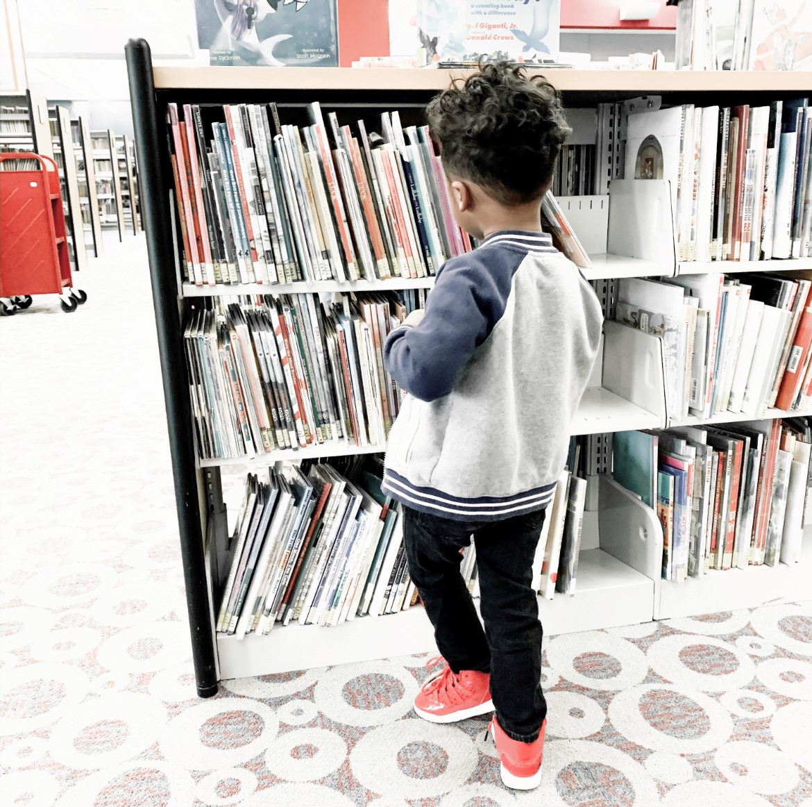 a kid standing in front of books